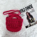 Detail of rose red crochet handbag with curved handle and detachable woven shoulder strap - Rose Red