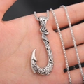Pendaglio a amo da pesca vintage in argento con motivi tribali tenuto in mano - Argento + Catena 60cm
