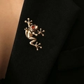 Charming golden frog brooch with red rhinestone eyes pinned on a black suit lapel - Frog with Red Eyes Style