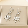 Detail of silver drop earrings with evil eye motif and white pearl on a gold box - Evil Eye Hollow Style / Steel Color (KE116258-GC)