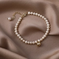 Elegant natural freshwater pearl bracelet with gold pendant on silk brown background - 26 Simple Waterdrop Pearl Bracelet