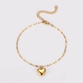 Detail of a golden stainless steel heart charm bracelet with shiny polished finish - Gold