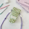 Detail of green and white quilted camera bag with heart button and woven purple strap - Plaid Green
