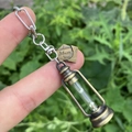 Detailed close-up of retro kerosene lamp keychain in bronze with glowing white particles - Style 9 (Love Tag + Lantern)