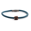Detailed macro of rose gold cylinder with black zircon inlay on a leather rope bracelet - Blue Gray