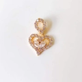 Close-up of golden heart pendant with shimmering crystals and pear-cut diamonds - Heart Zirconia*Gold