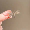 Elegant gold dragonfly brooch with crystal-studded wings held against a neutral backdrop - 439# Dragonfly