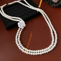 Dettaglio di una collana di perle a doppio strato con un pendente a fiore di camelia bianca - Bianco