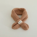 Detailaufnahme des camel-farbenen Strickschals mit Markenetikett auf minimalistischem Grund - Kleines Etikett Stil / Khaki