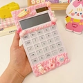 Détail d'une calculatrice DIY en colle crème rose avec des breloques mignonnes tenue à la main - Ensemble Rose (Accessoires/Colle Crème/Calculatrice Inclus)
