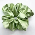 Detailansicht eines hellgrünen Satin-Haargummis mit glänzendem Stoff und Faltenstruktur - 20cm / Hellgrün