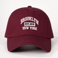 Close-up of white Brooklyn New York embroidery on wine red cotton baseball cap - One Size / Burgundy