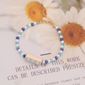 Detalle de pulsera de cristales con dije LOVE rosa y cierre dorado ajustable - Estilo LOVE Rosa