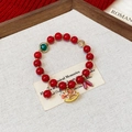Close-up of red beaded bracelet with emerald charm and festive rocking horse pendant - Vintage Enamel Rocking Horse Beads (Style 8)