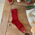 Dicke rote Weihnachtsstrümpfe mit Zopfmuster und Wellensaum auf festlichem Holzhintergrund - Rot Gedreht