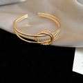 Dettaglio del bracciale dorato a nodo intrecciato con fasce multiple e texture a corda - Stile 42 - Oro