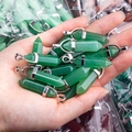 Detailopname van hexagonale groene kristallen hangers in de hand voor maatvergelijking - Groene Aventurijn