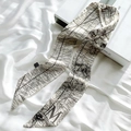 Detailed view of silk twilly with leopard print and bold letter M on white satin - Sketch Spring Letter M