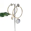 Detailed view of 50mm gold stainless steel hoop earrings with natural shell pendants - 50mm