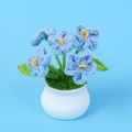 Close-up of hand-crocheted blue forget-me-not potted plant in a white ceramic base - Blue