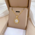 Macro detail of gold sunburst pendant with sparkling white crystals in a beige jewelry box - Sunburst Zirconia Pendant (H321)