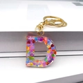 Detail of a transparent resin D-letter keychain with colorful heart-shaped sequins and gold hardware - Letter D Lobster Clasp Keychain