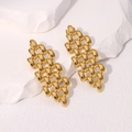 Gold geometric chain link drop earrings displayed on a white textured stone pedestal - Gold