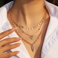 Dettaglio della collana multistrato dorata con ciondoli a triangolo di strass su modella - 3 strati triangolo / Fibbia a Triangolo Oro