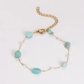 Detail of gold chain bracelet with green turquoise stones and white pearls on white background - Bracelet