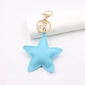 Detail of light blue PU leather star keychain with cross-grain texture and gold clasp - Blue