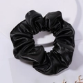 Detail of a black faux leather hair scrunchie with soft pleated texture on white background - Black