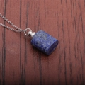 Close-up of cylindrical lapis lazuli perfume bottle pendant on a silver metal chain - Lapis Lazuli Perfume Bottle