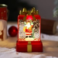 Detail van de Kerstman en kerstboom in een rood gloeiende lantaarn in de vorm van een cadeau - Kerstman
