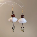 Detail of wooden bead earrings with tiger eye stone and acorn pendants on a transparent rack - Gold And Coffee Ear Hook
