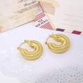Macro detail of golden twist earrings with textured spiral design on vintage background - Gold Spiral Textured Hoop
