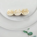 Macro detail of three-head cream acetate cat hair clip with marble texture on white plate - Iridescent White