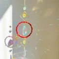 Golden suncatcher with red natural stones and crystal prisms casting rainbow light - Red Jade