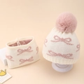 Dettaglio del cappello in maglia per neonati con fiocco rosa e pompon decorativo - Bianco