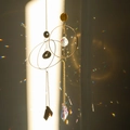 Golden suncatcher with clear crystal ball casting rainbow light patterns on wall - Style 5 Round