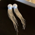 Nahaufnahme eleganter Perlenohrringe mit langen silbernen Quasten auf schwarzem Hintergrund - Silberne Perle Quaste