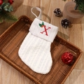 White knitted Christmas stocking with red embroidered letter X and winter holly decoration - Letter X