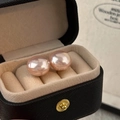 Macro detail of high-luster pink pearl earrings in a black textured jewelry box - Sakura Pink 14mm