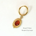 Detail view of gold hoop earrings with red-brown gemstone and sunburst texture - Red Agate Oval