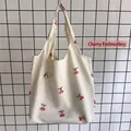 Close-up of detailed red cherry embroidery on a white canvas tote bag with textured fabric - Cherry Embroidery Canvas Bag