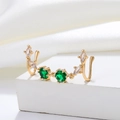 Macro shot of gold-plated U-shaped faux nose ring with green gems and white zircons - Double Nostril Linked Nose Cuff (S560) / KC Gold (Inlaid Green Zirconia)