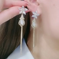 Detailansicht langer Quastenohrringe mit Blumensteckern und Katzenaugenstein am Modell - Weiße Blume Katzenaugenstein Quaste Stil (ER22Y0849) / Gold+Weiß