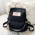 Sac à dos femme en tissu Oxford noir avec détails en cuir rose et pendentif à pompon - Noir