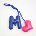 Close-up of leather letter M and heart charm with professional handmade stitching detail - Rose Red Heart and Royal Blue M