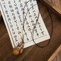 Detail of vintage acorn pendant necklace with wooden beads on a rustic wooden tray - Coffee Large Acorn Woven Style (7# Necklace)