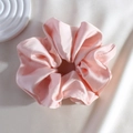 Close-up of pink satin silk scrunchie showing smooth texture and elegant folds - Pink